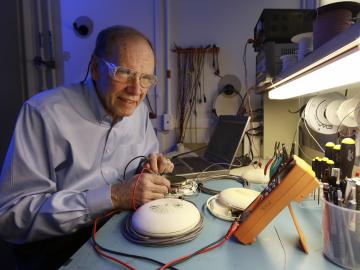 researcher in a button-down shirt works with electrical measurement equipment